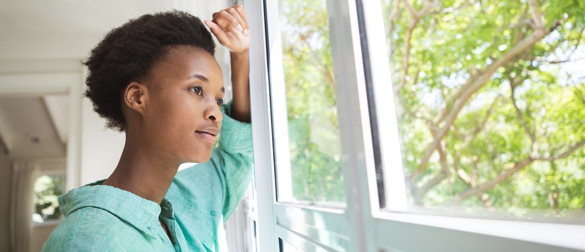 Woman contemplatively looking out of a window