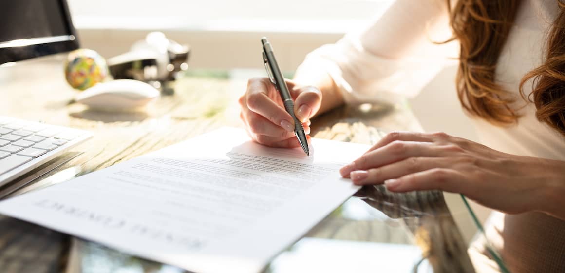 Woman signing a contract.
