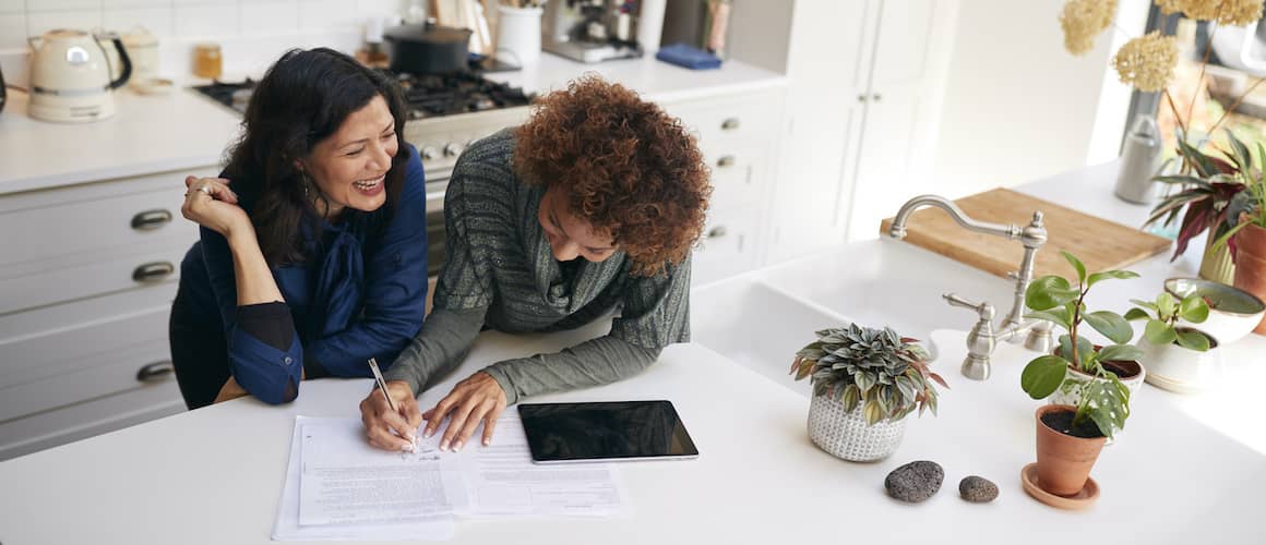 two women doing finances in kitchen