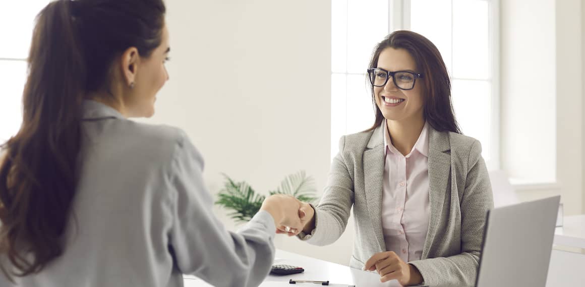 women shaking hands at a meeting