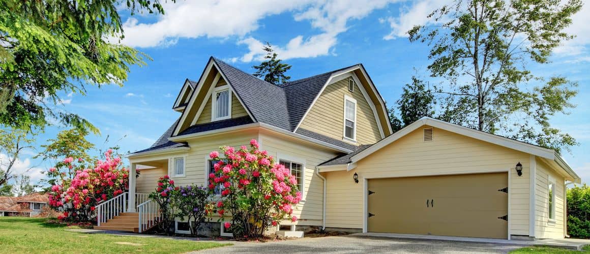 Yellow house with pink flowers.