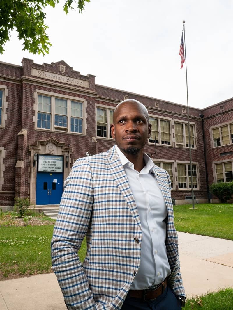 Michael posing outside of Stedman Elementary, where he’s the principal.