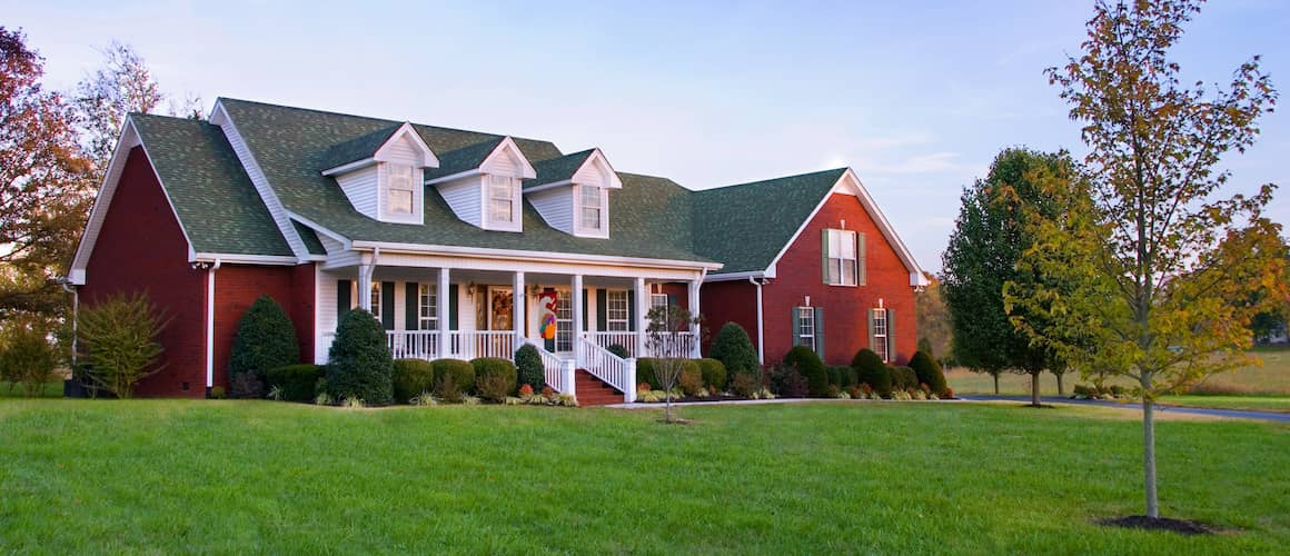A large brick house in the country at dusk