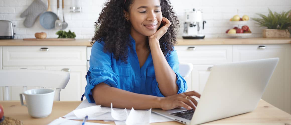 Afro American Woman Using Portable Computer And Smiling