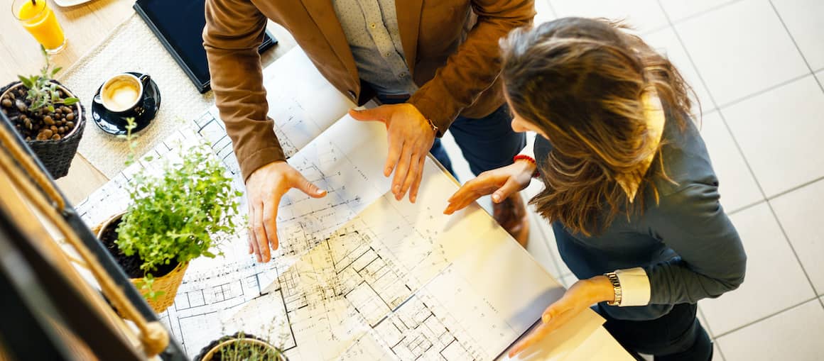 Two young professionals reviewing building designs.