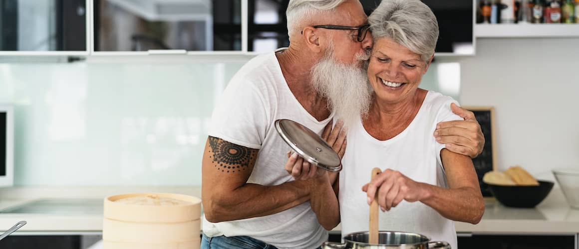 Retired couple cooking in their kitchen together.