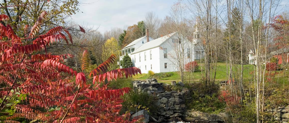 Colonial house in Massachusetts with forest in foreground.