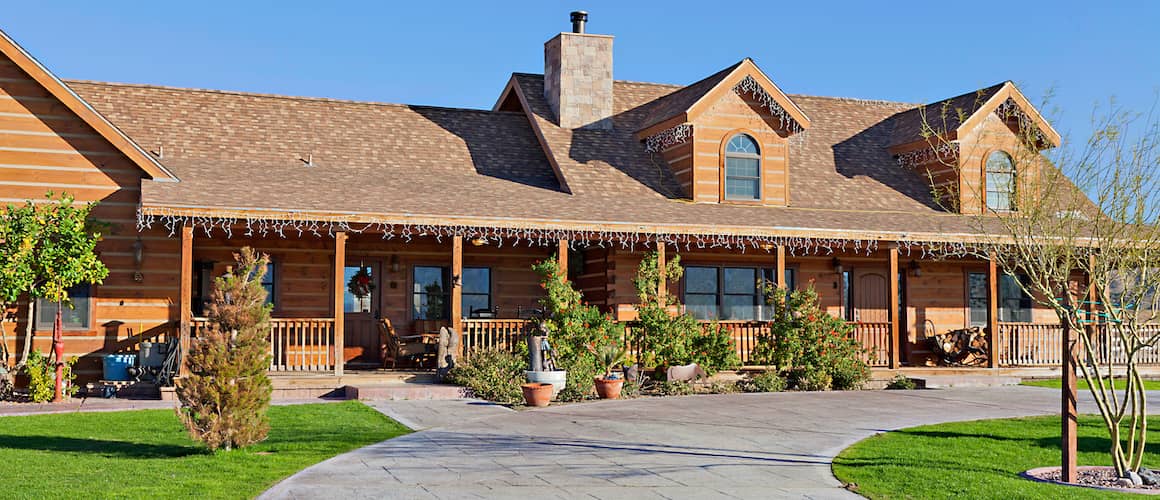 Brown ranch house with many potted plants outside decorated for the holidays in a warmer region.