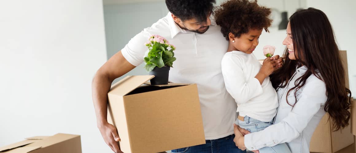 Family moving in with child presenting flower.