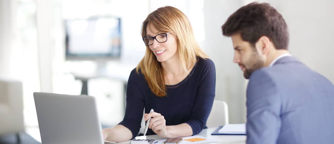 Financial advisor meeting with a client and looking at laptop.