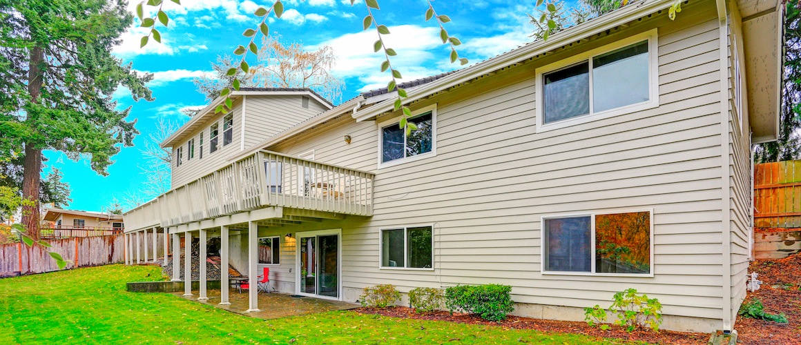 House with large porch and lawn.