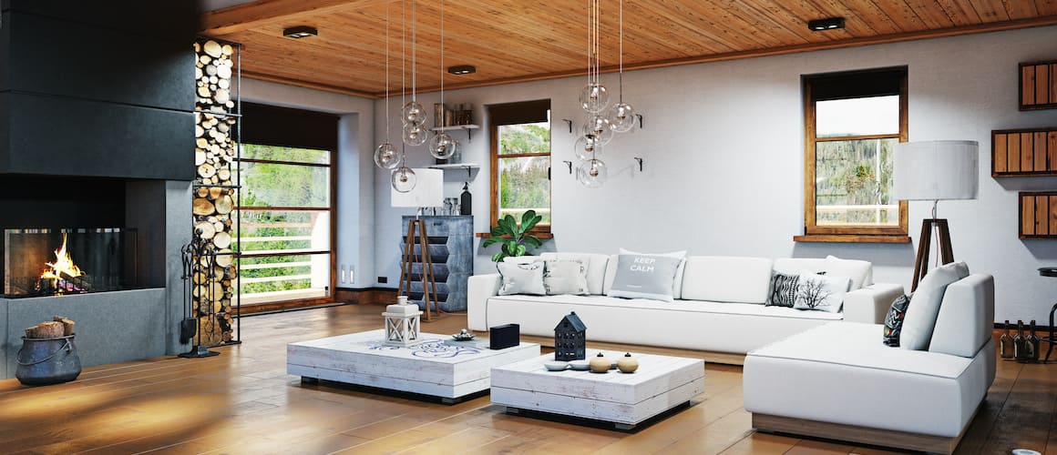 Interior of open style high ceiling living room with white couches and fireplace.