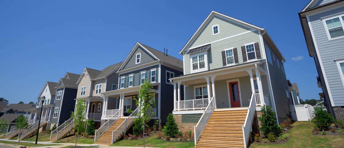 Row of two story homes with covered porches.
