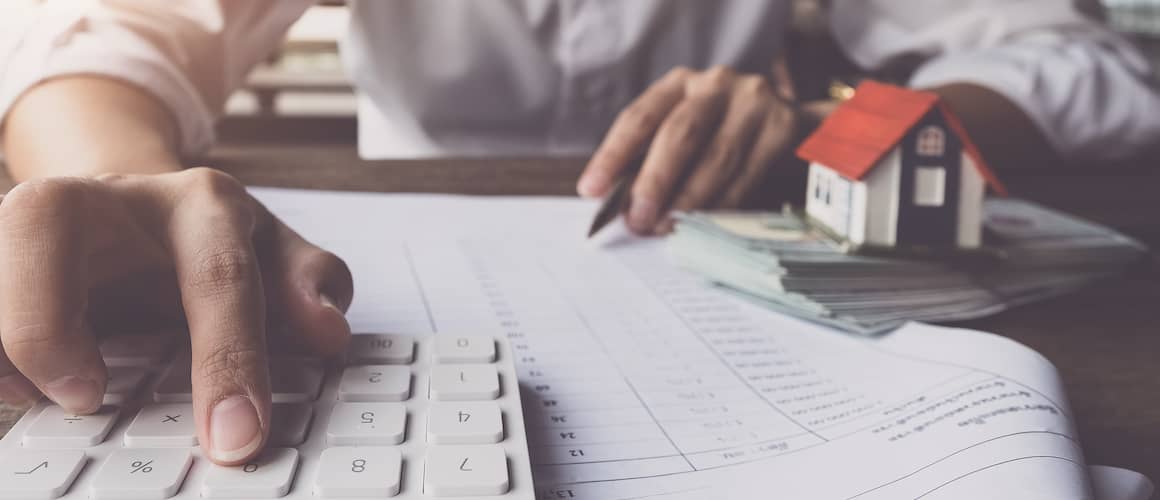 Man Putting Numbers Into Calculator