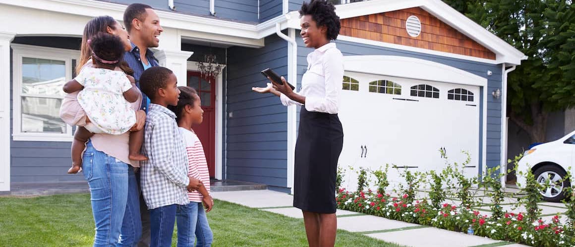 Real estate agent showing a family a house.