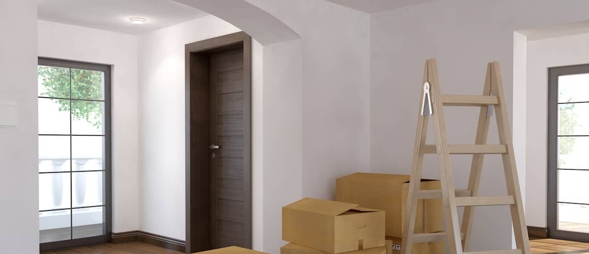 Ladder and moving boxes stacked in an empty house.