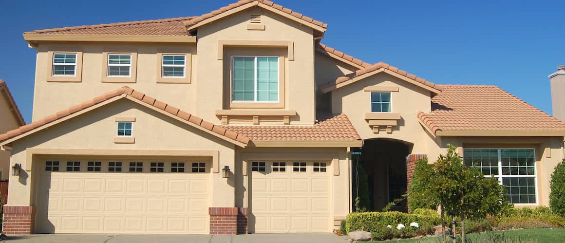 Tan, two-story house with two garages.