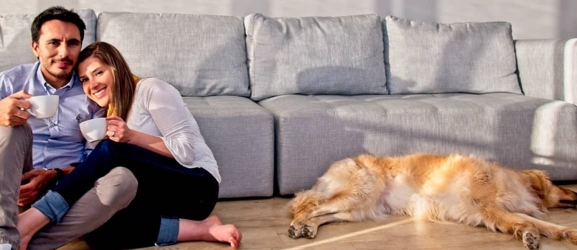 Veteran In Civilian Clothes Snuggling Partner With Golden Retriever Laying Nearby
