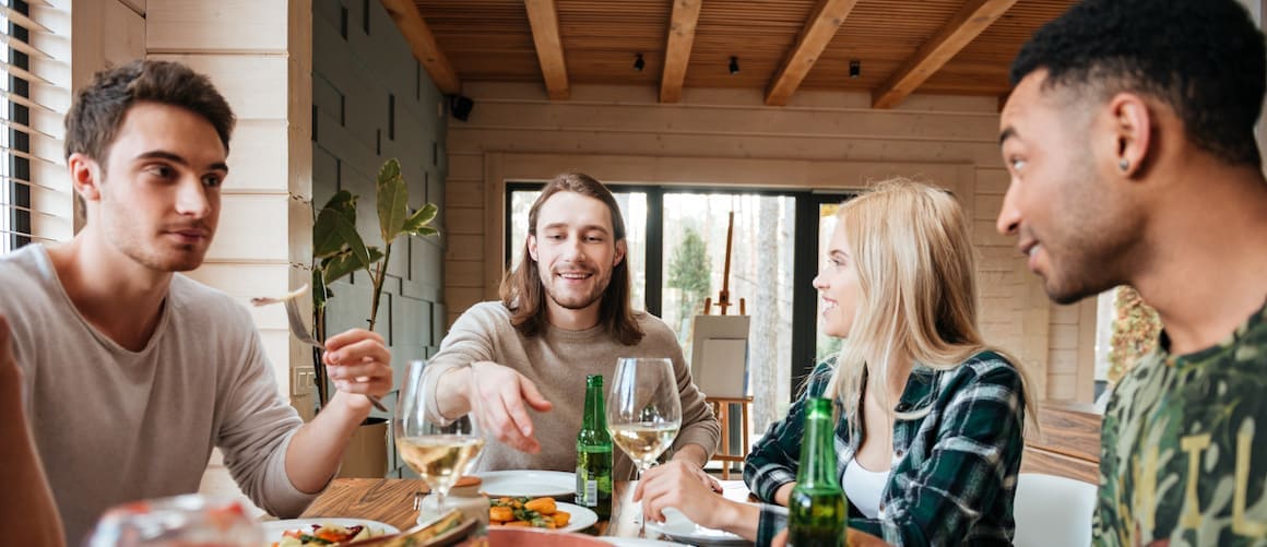 Group of friends having dinner at housewarming party.