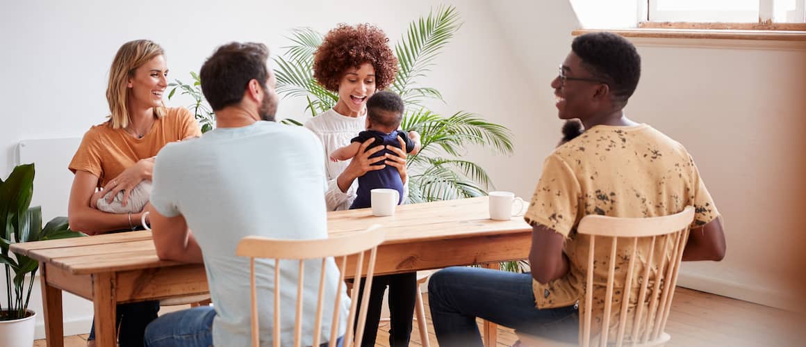 Young families at dinner table during playdate with babies.