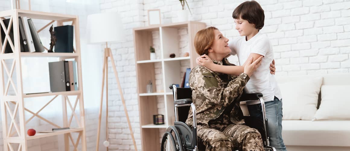 Woman Veteran In Wheelchair And Son Hugs Her