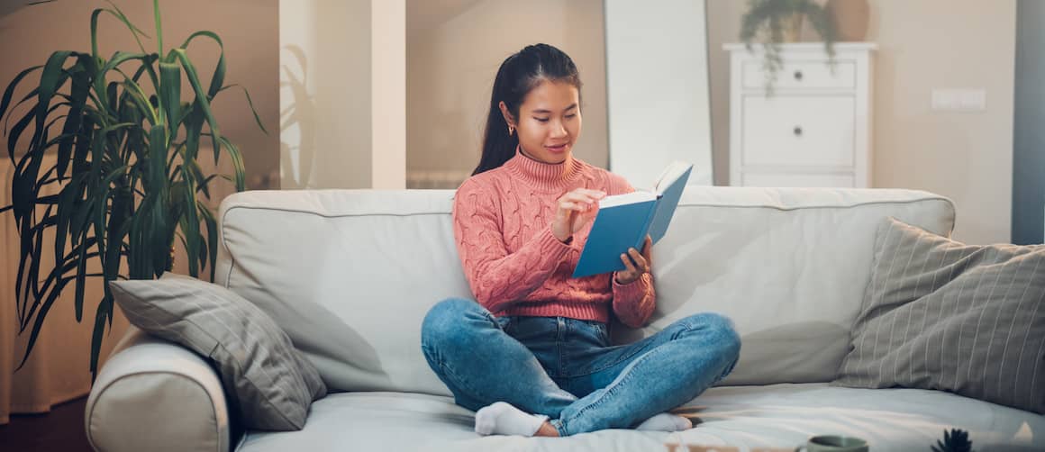 Young woman reading on couch.