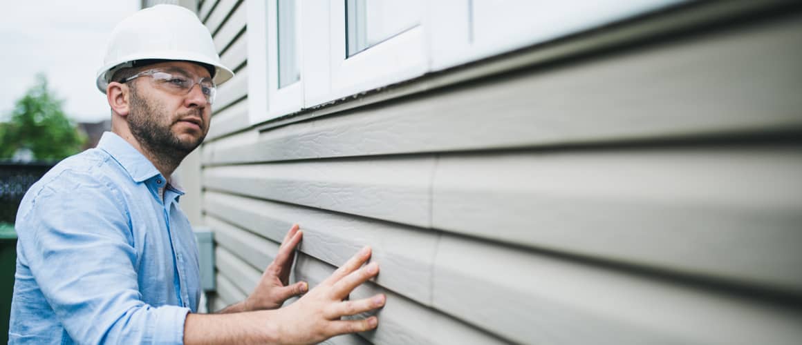 Building inspector checking out home siding.