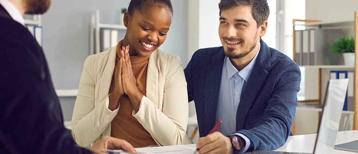 Happy couple meeting with mortgage lender.