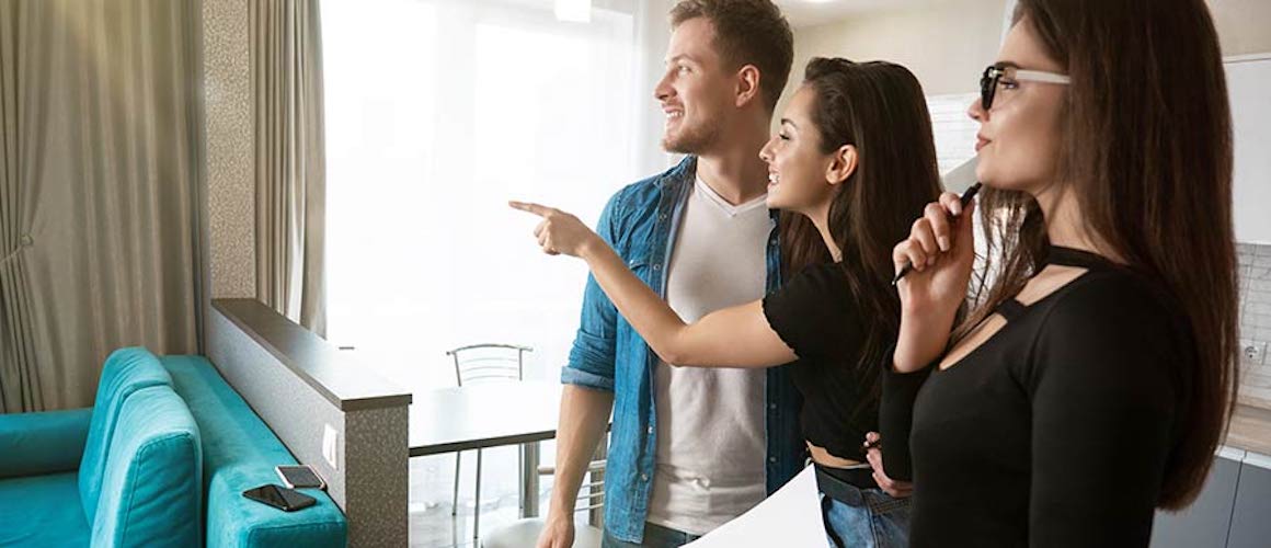 Couple viewing house for sale with real estate agent.