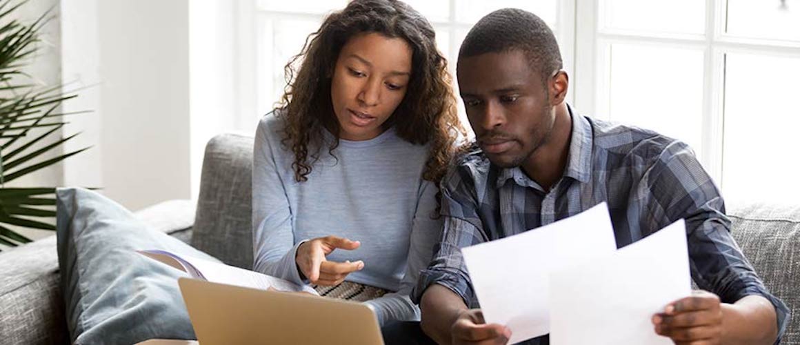 Couple reviewing finances together on couch.